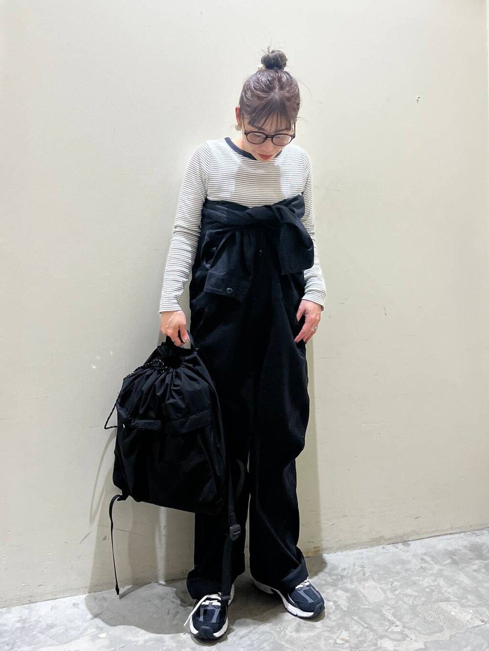 ブラック系のバックパック/リュック、ベージュ系のTシャツ/カットソー、ブラック系のつなぎ/オールインワンを着用したレディースの春コーディネートの5枚目の写真