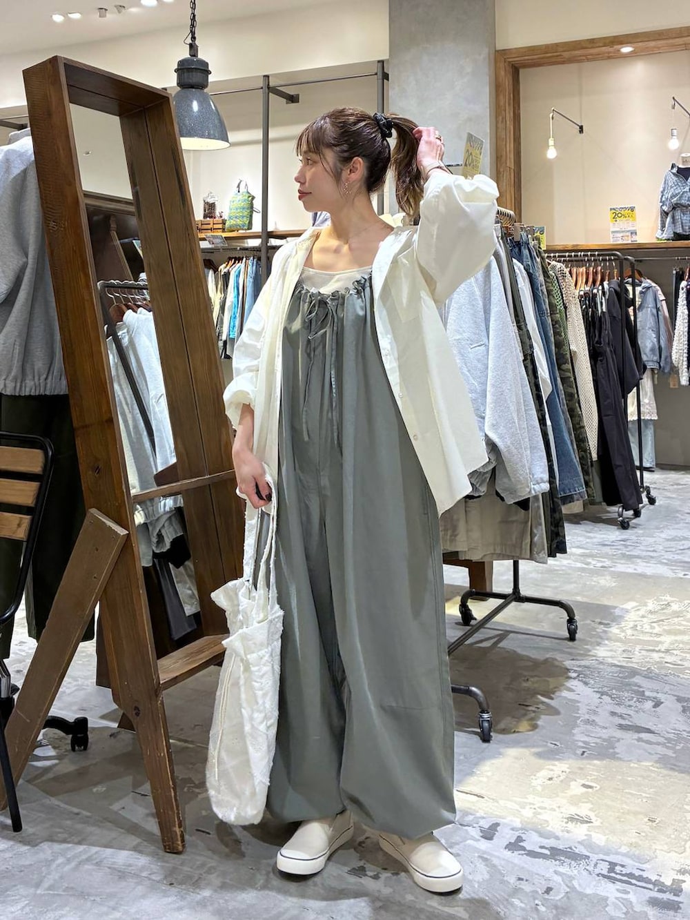 グリーン系のサロペット/オーバーオール、ホワイト系のシャツ/ブラウス、ベージュ系のタンクトップを着用したレディースの春コーディネートの5枚目の写真