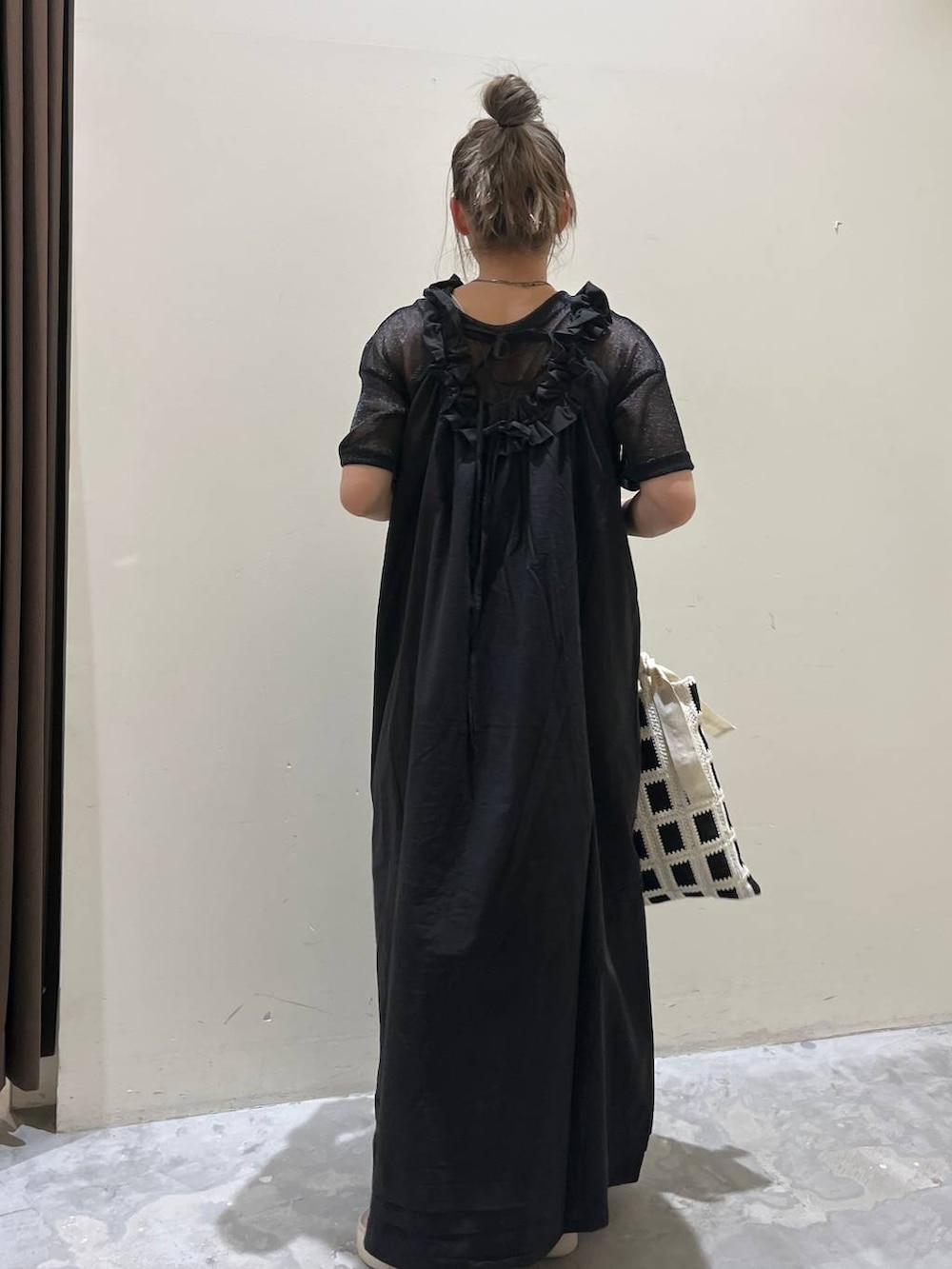 ベージュ系のサンダル、ブラック系のワンピース、ブラック系のトートバッグを着用したレディースの春コーディネートの6枚目の写真