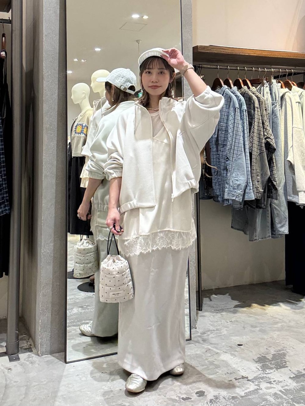 ゴールド系のスニーカー、ホワイト系のショルダーバッグ、ベージュ系のブルゾンを着用したレディースの春コーディネートの2枚目の写真