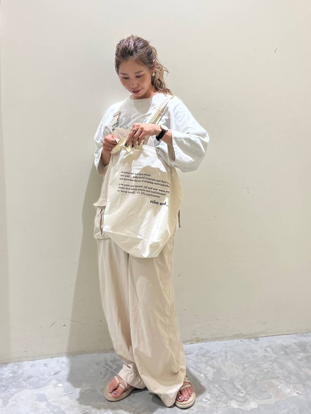 ベージュ系のサロペット/オーバーオール、ベージュ系のTシャツ/カットソー、ベージュ系のサンダルを着用したレディースの夏コーディネートの3枚目の写真