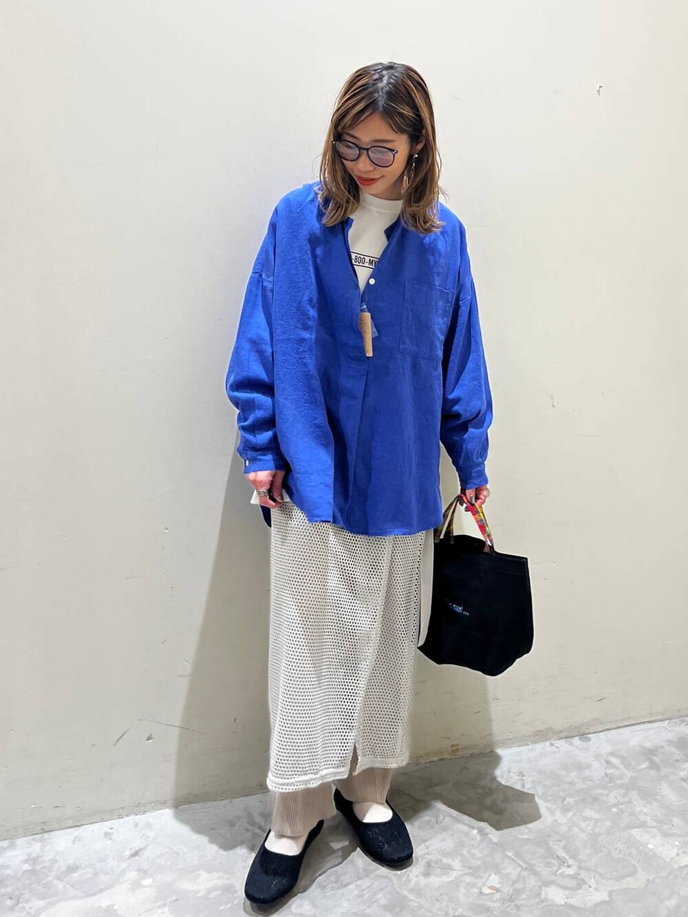 グレー系のスカート、ブラック系のその他シューズ、ブラック系のトートバッグを着用したレディースの春コーディネートの3枚目の写真