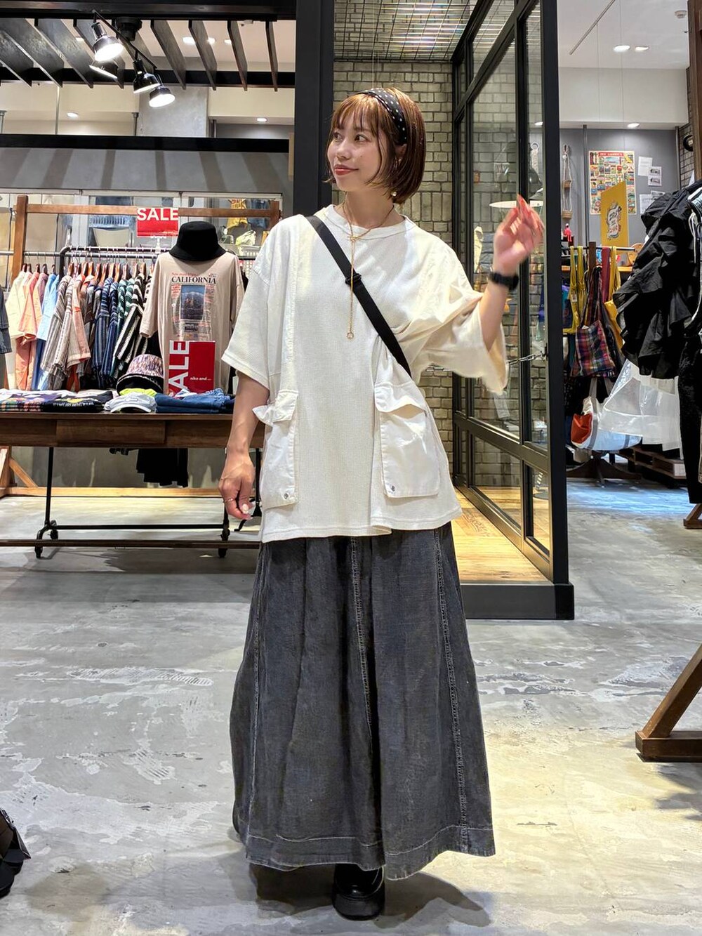 グレー系のスカート、ベージュ系のTシャツ/カットソー、ブラック系のショルダーバッグを着用したレディースの夏コーディネートの5枚目の写真