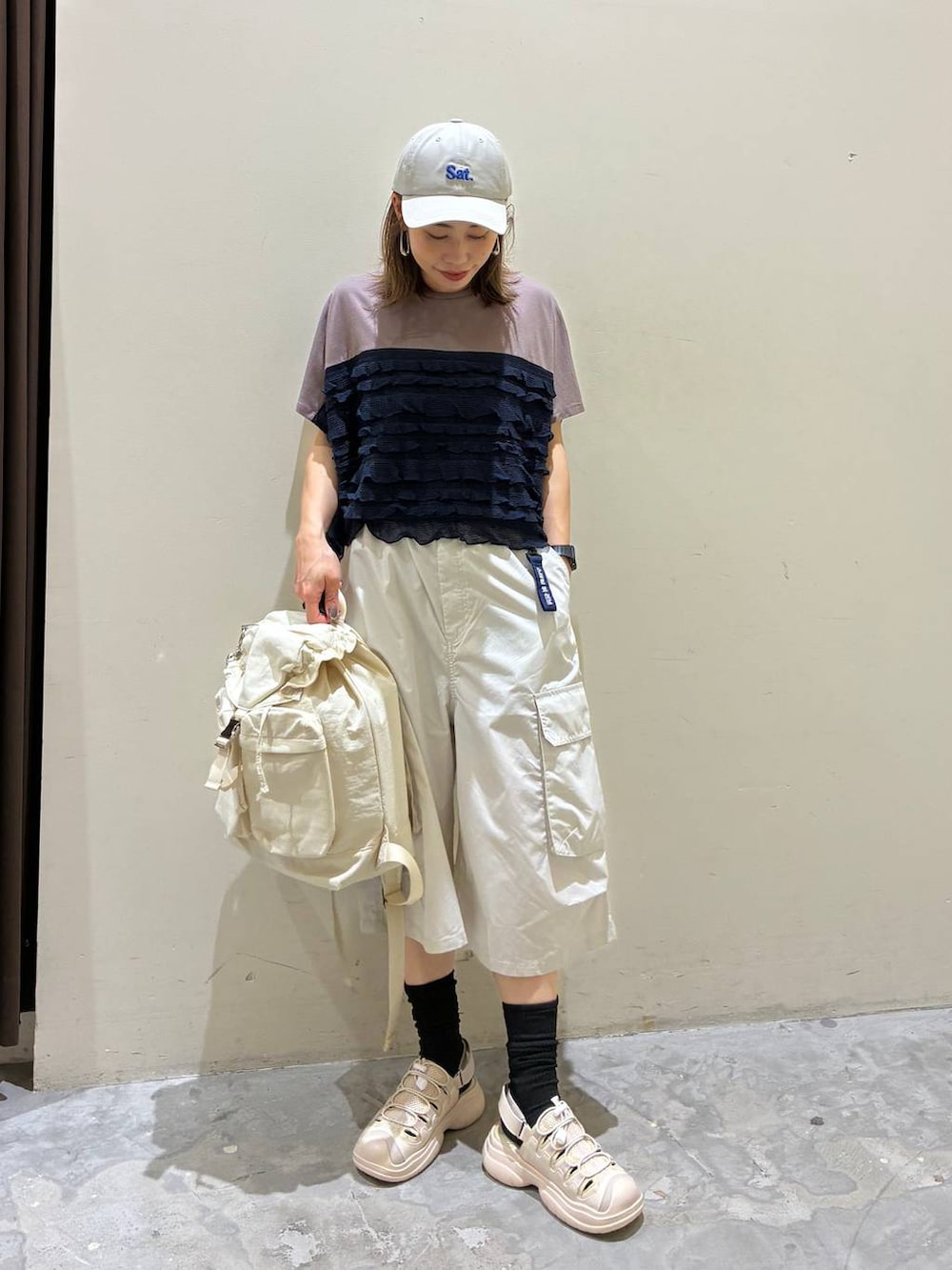 ベージュ系のバックパック/リュック、ベージュ系のサンダル、グレー系のその他パンツを着用したレディースの夏コーディネートの5枚目の写真