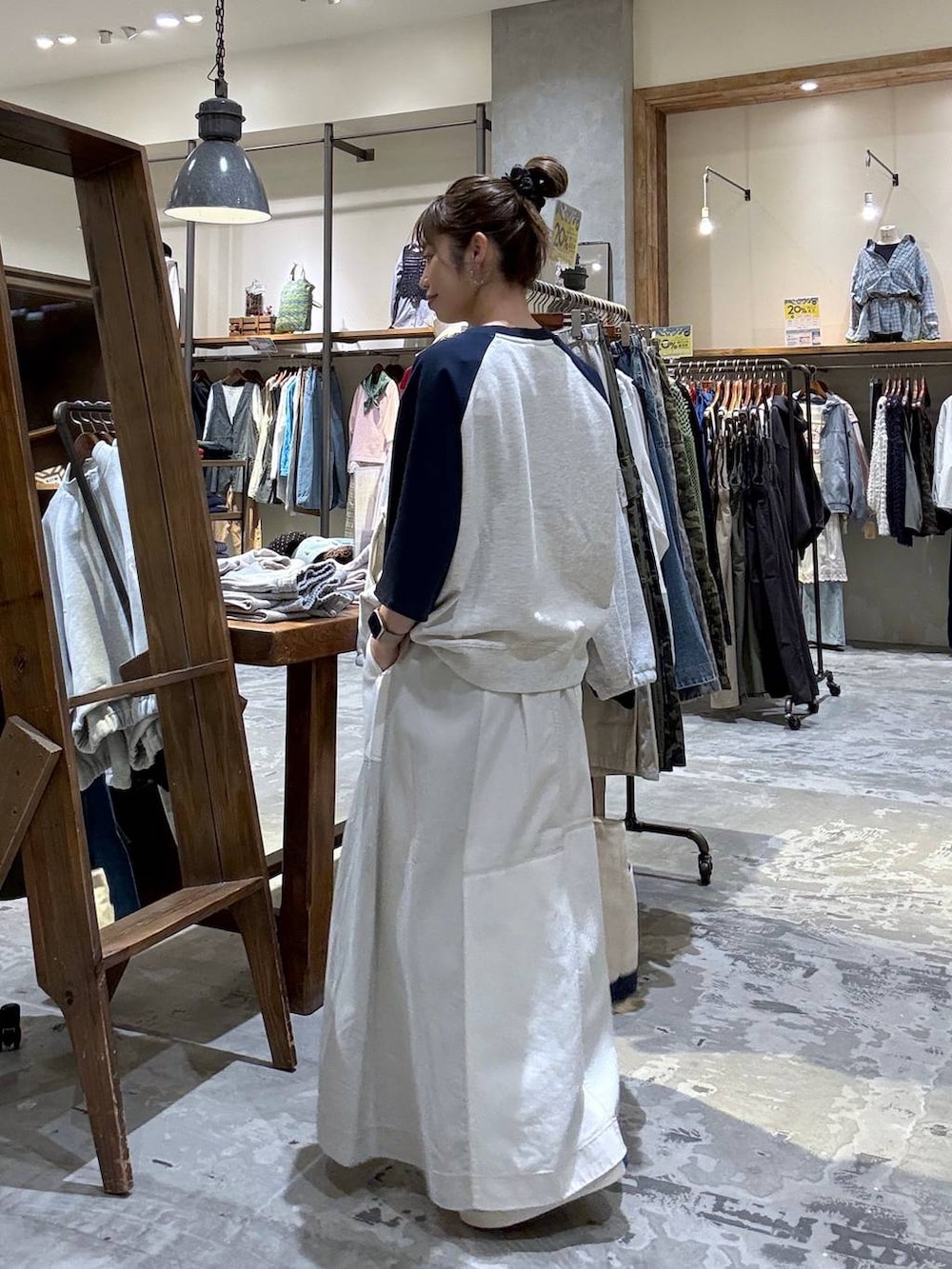 ベージュ系のトートバッグ、ベージュ系のTシャツ/カットソー、ベージュ系のスカートを着用したレディースの春コーディネートの2枚目の写真