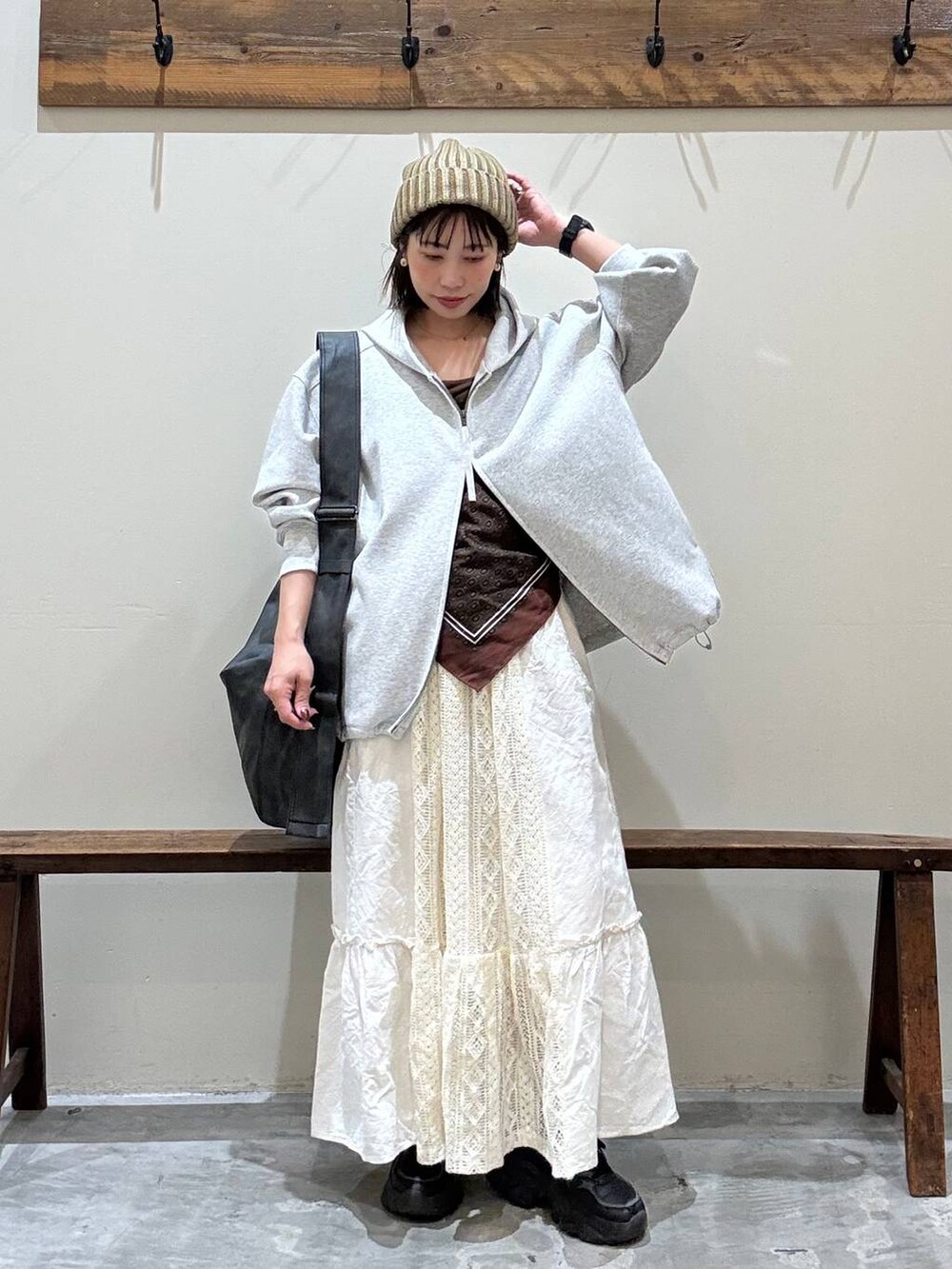 ベージュ系のスカート、ブラック系のショルダーバッグ、グレー系のパーカーを着用したレディースの秋コーディネートの4枚目の写真