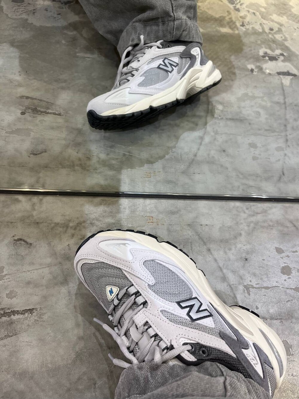 グレー系のデニムパンツ、グレー系のスニーカー、ブラック系のTシャツ/カットソーを着用したレディースの春コーディネートの2枚目の写真