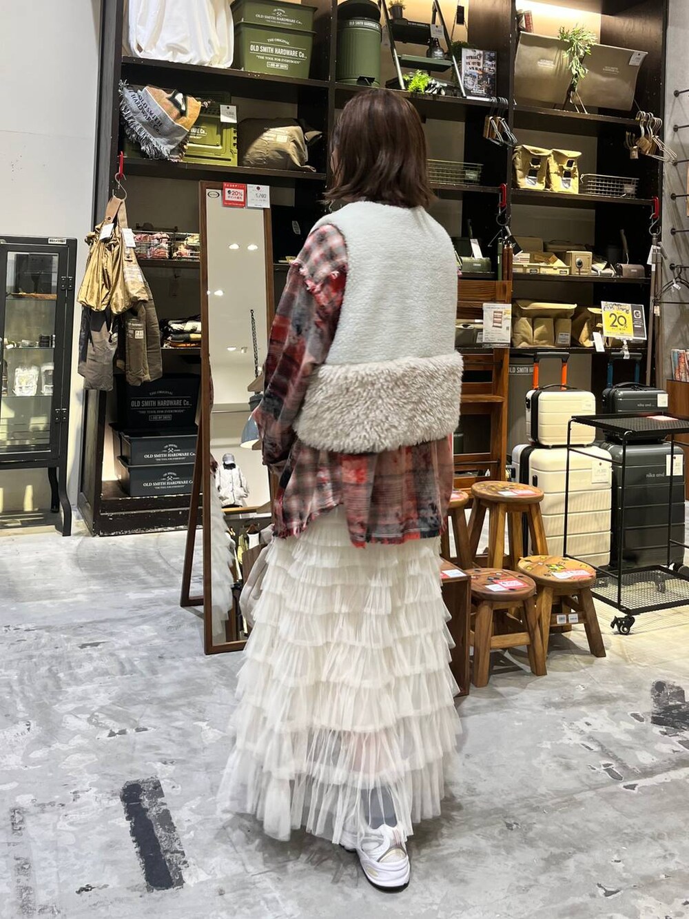 ホワイト系のスニーカー、レッド系のシャツ/ブラウス、ベージュ系のベストを着用したレディースの秋コーディネートの4枚目の写真