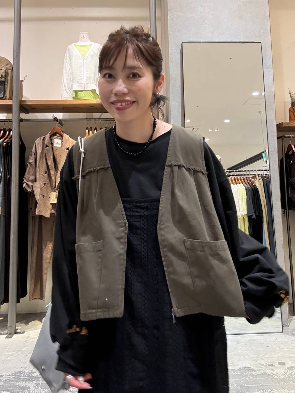 ブラック系のワンピース、ブラック系のスニーカー、シルバー系のショルダーバッグを着用したレディースの秋コーディネートの2枚目の写真