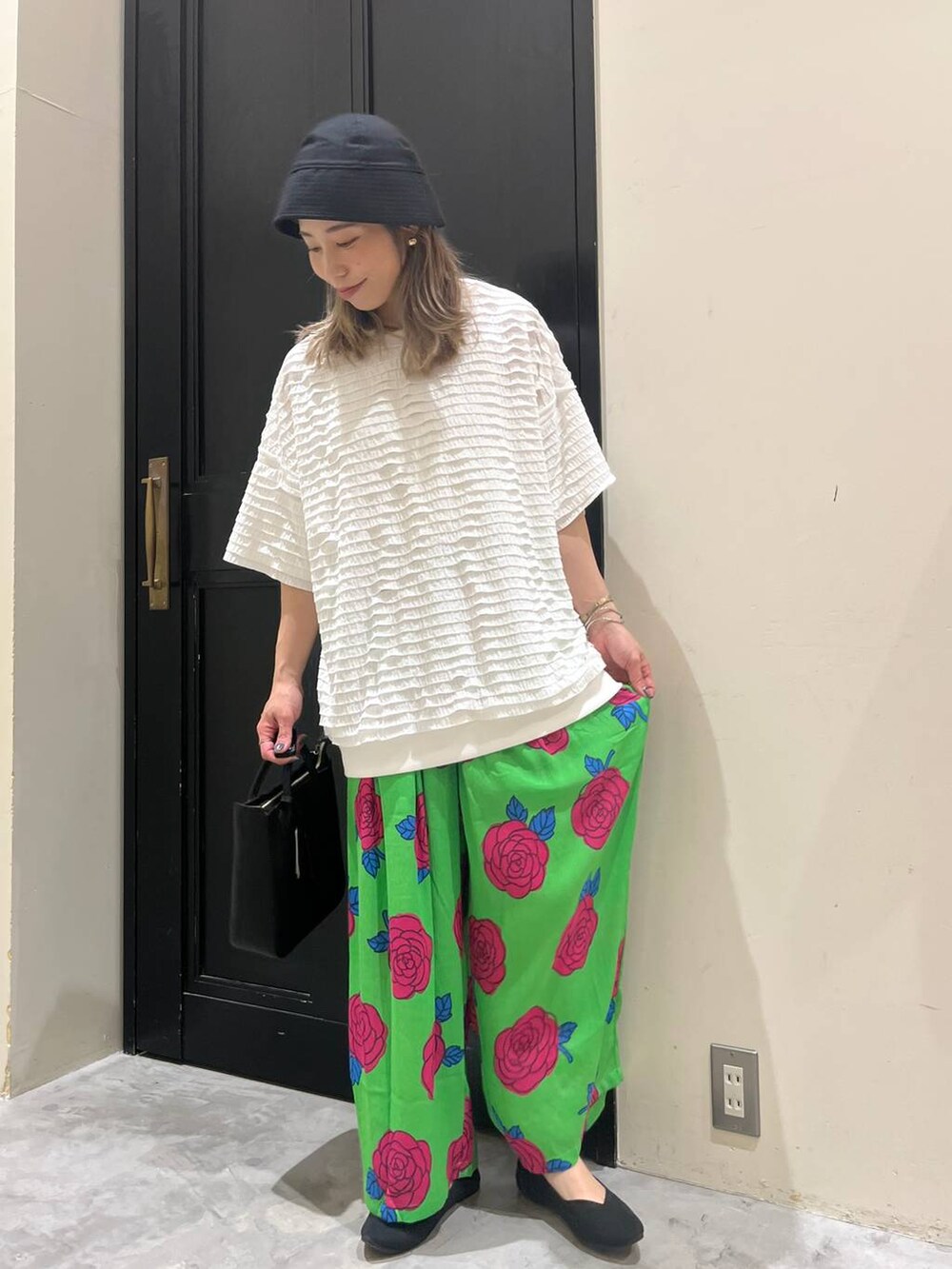 ブラック系のトートバッグ、ブラック系のパンプス、ホワイト系のTシャツ/カットソーを着用したレディースの春コーディネートの3枚目の写真