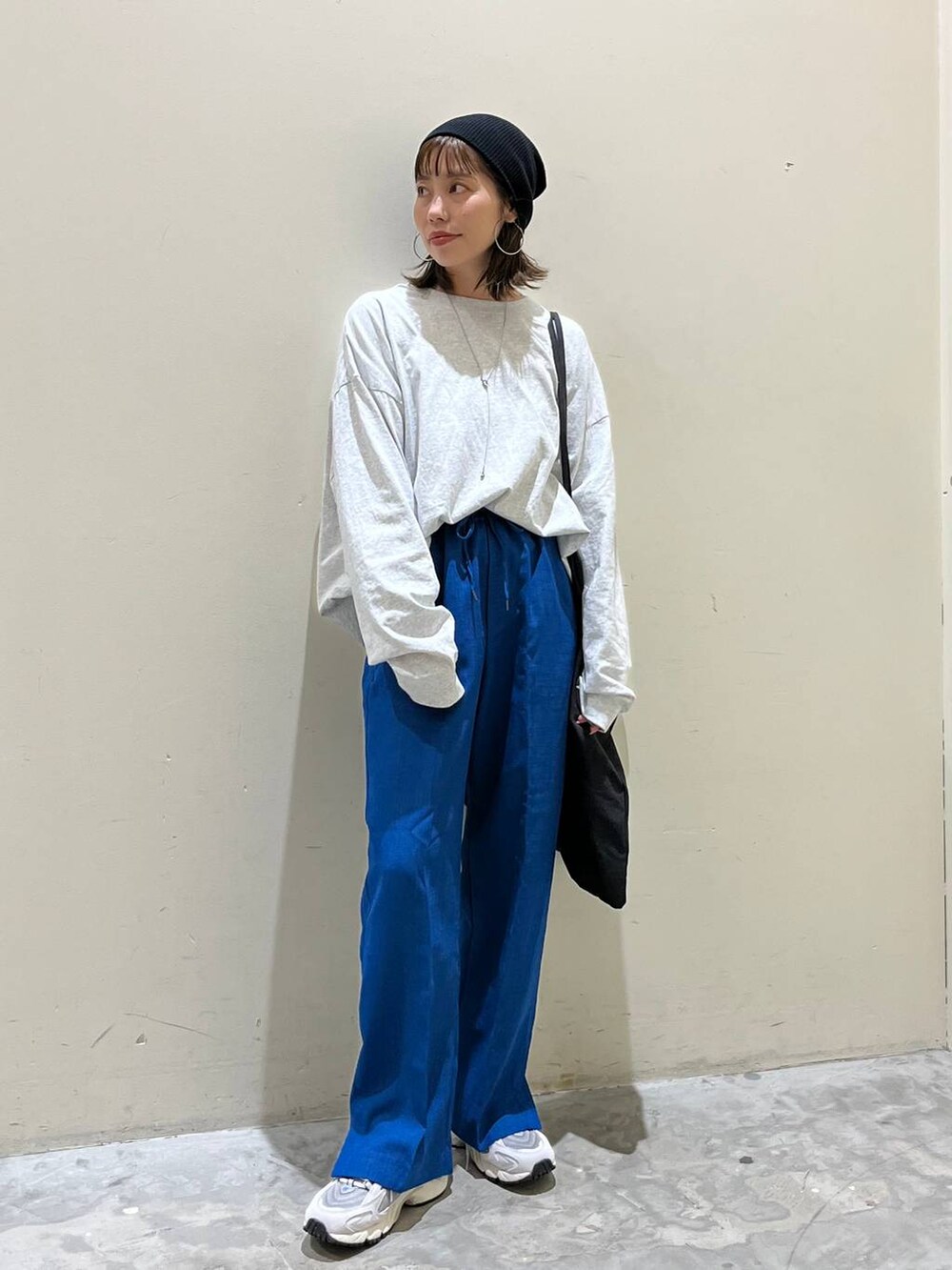 グレー系のトートバッグ、グレー系のTシャツ/カットソー、グレー系のスニーカーを着用したレディースの春コーディネートの4枚目の写真