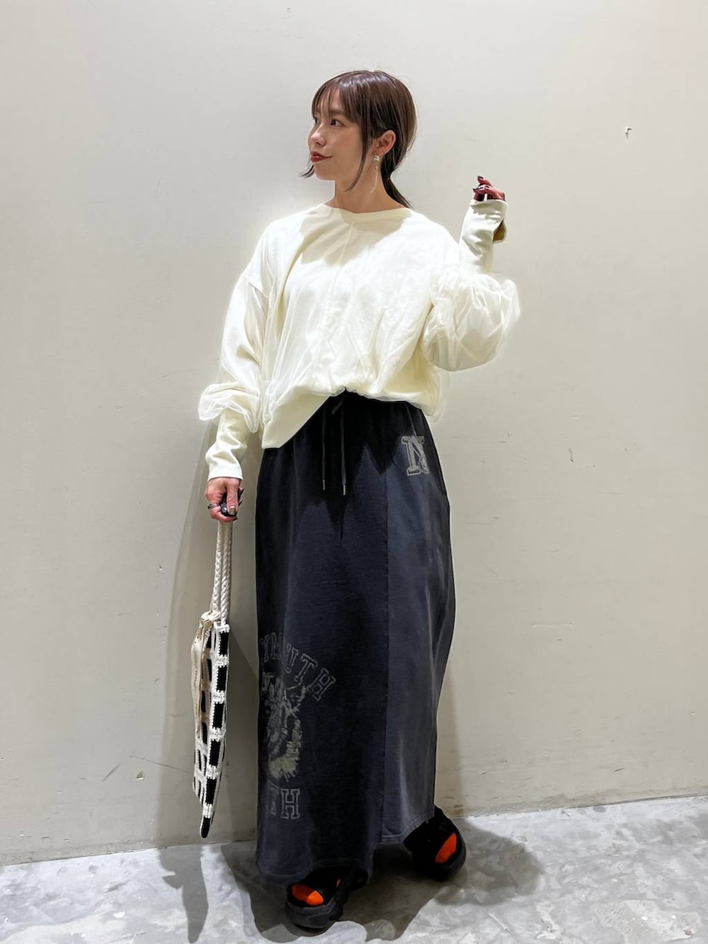 ホワイト系のスウェット、ブラック系のトートバッグ、その他のスカートを着用したレディースの春コーディネートの5枚目の写真