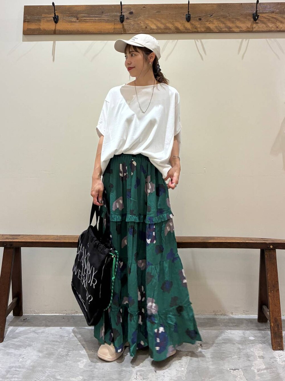 ブラック系のトートバッグ、グリーン系のスカート、ベージュ系のサンダルを着用したレディースの夏コーディネートの7枚目の写真