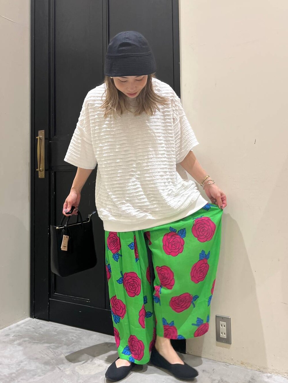 ブラック系のトートバッグ、ブラック系のパンプス、ホワイト系のTシャツ/カットソーを着用したレディースの春コーディネートの4枚目の写真