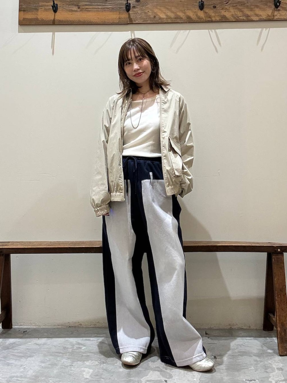 ゴールド系のスニーカー、ブルー系のデニムパンツ、イエロー系のブルゾンを着用したレディースの冬コーディネートの4枚目の写真