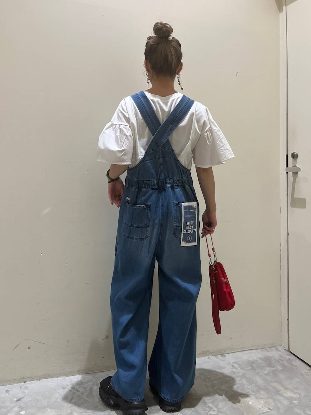 ホワイト系のTシャツ/カットソー、ブラック系のサンダル、レッド系のショルダーバッグを着用したレディースの春コーディネートの4枚目の写真