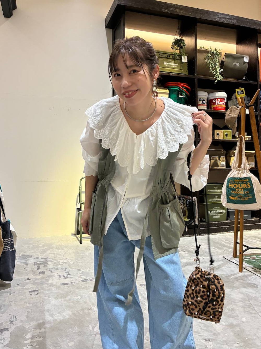 その他のショルダーバッグ、ゴールド系のスニーカー、グリーン系のベストを着用したレディースの冬コーディネートの2枚目の写真