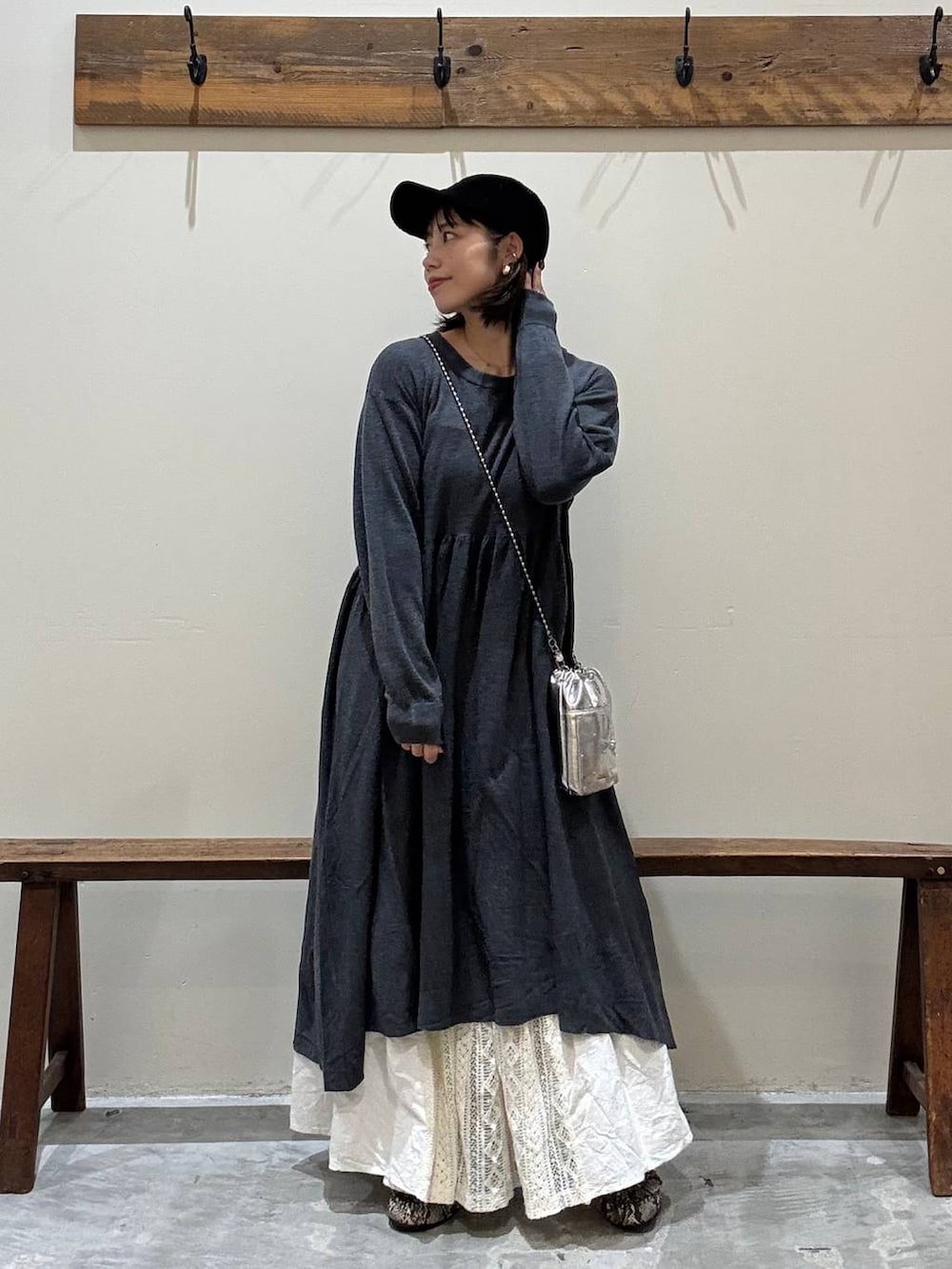 シルバー系のショルダーバッグ、グレー系のワンピース、ベージュ系のスカートを着用したレディースの秋コーディネートの3枚目の写真