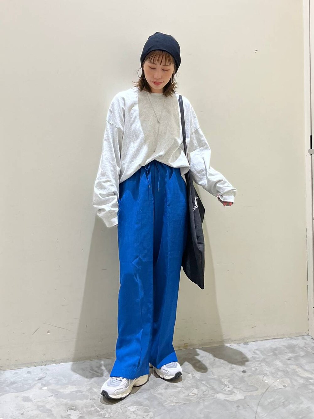 グレー系のトートバッグ、グレー系のTシャツ/カットソー、グレー系のスニーカーを着用したレディースの春コーディネートの3枚目の写真