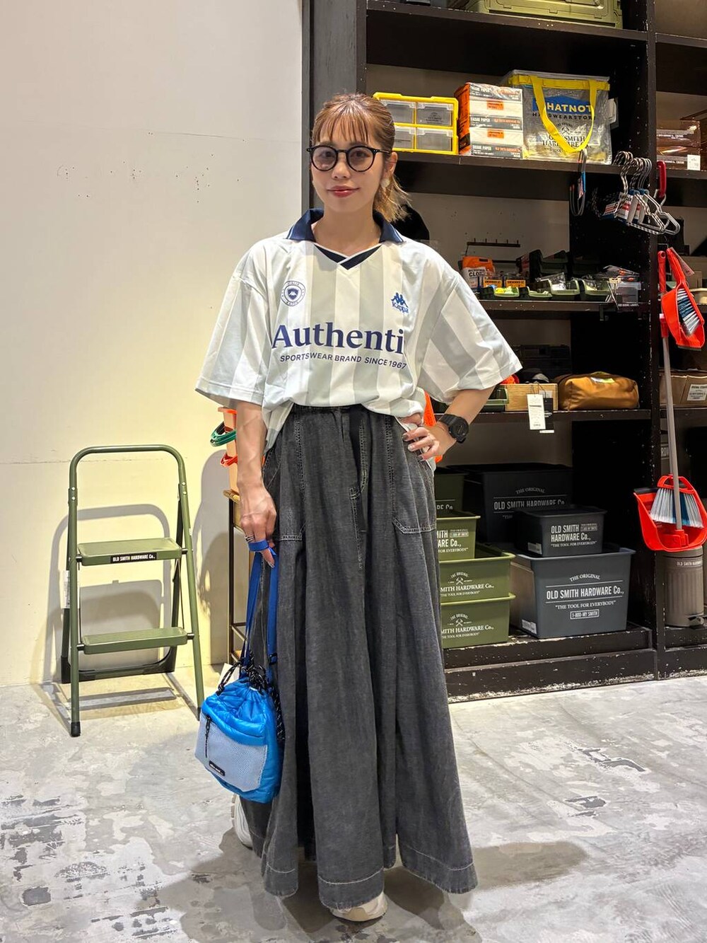 グレー系のスカート、ホワイト系のシャツ/ブラウス、ブルー系のショルダーバッグを着用したレディースの夏コーディネートの4枚目の写真