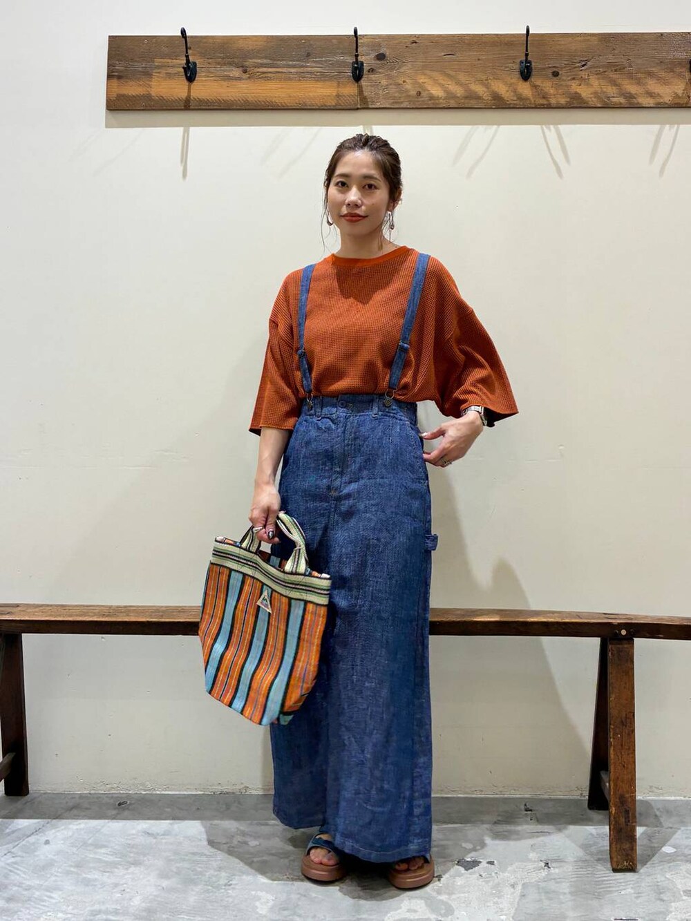 ブルー系のスカート、ブルー系のサンダル、オレンジ系のトートバッグを着用したレディースの春コーディネートの8枚目の写真