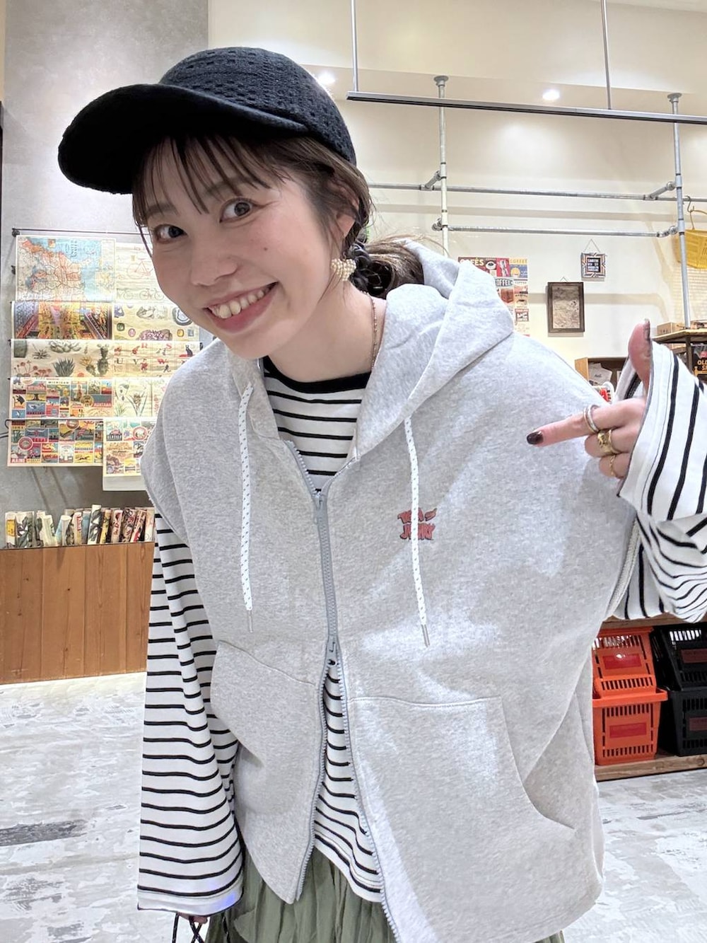 ブラック系のショルダーバッグ、ホワイト系のTシャツ/カットソー、グレー系のベストを着用したレディースの春コーディネートの2枚目の写真