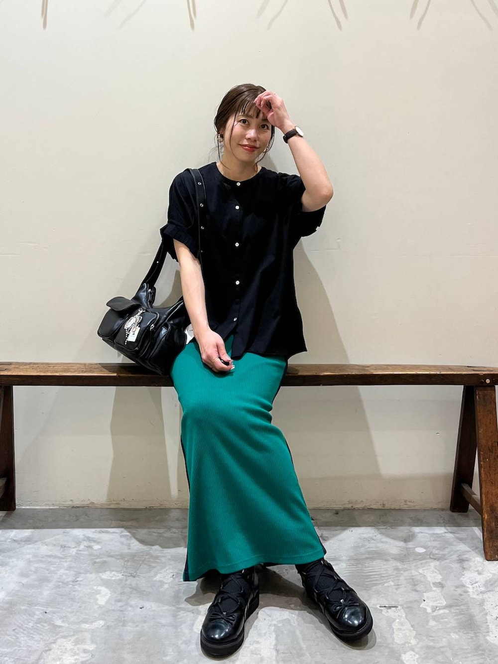 グリーン系のスカート、ブラック系のショルダーバッグ、ブラック系のバレエシューズを着用したレディースの春コーディネートの3枚目の写真