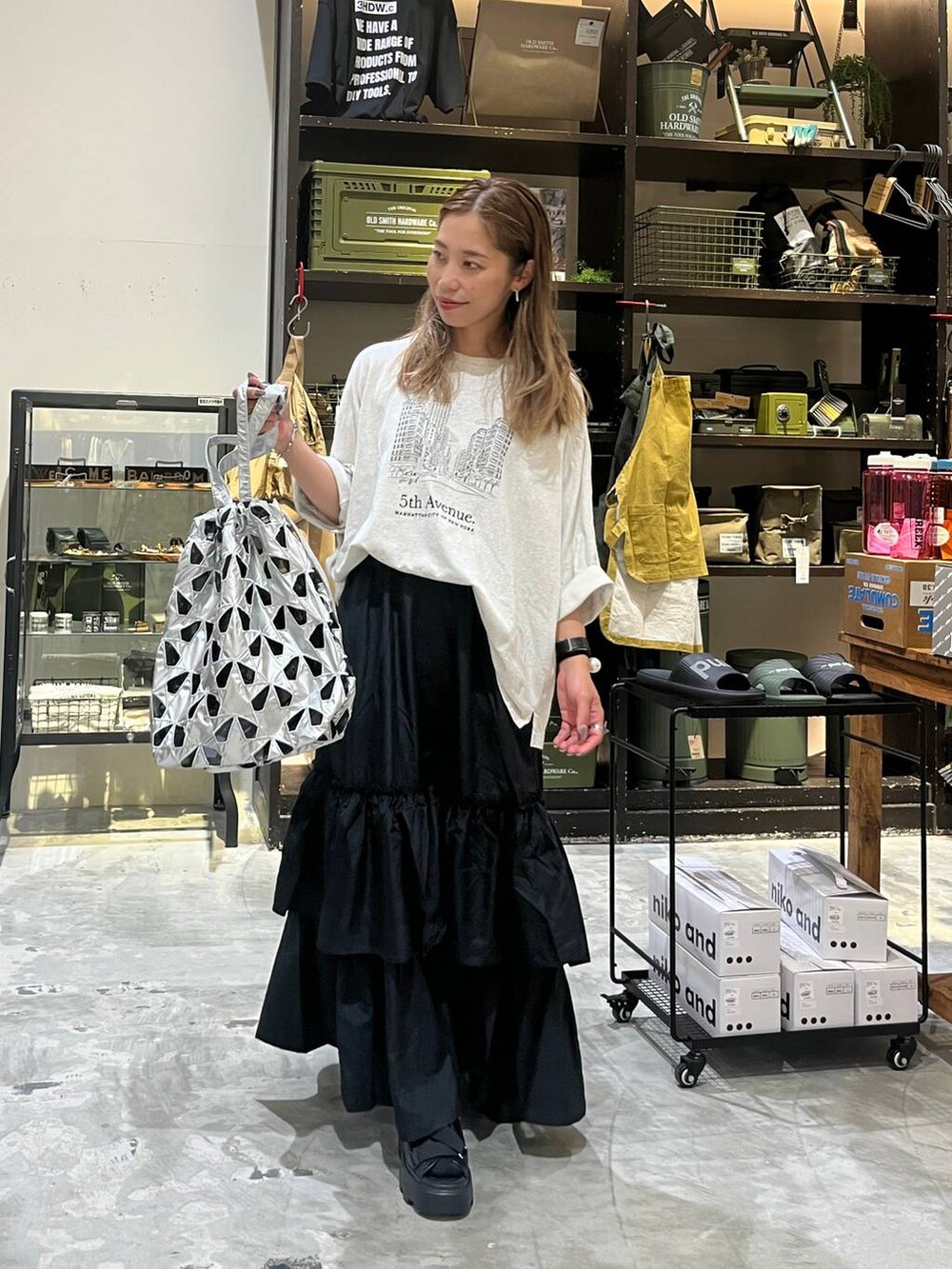 ベージュ系のTシャツ/カットソー、その他のトートバッグ、ブラック系のスカートを着用したレディースの夏コーディネートの4枚目の写真