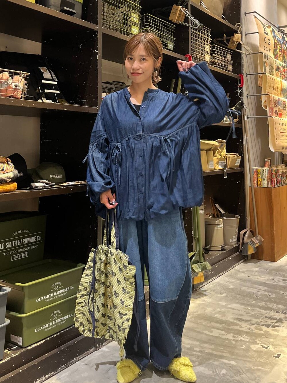 ベージュ系のトートバッグ、ブルー系のデニムパンツ、イエロー系のバレエシューズを着用したレディースの秋コーディネートの2枚目の写真