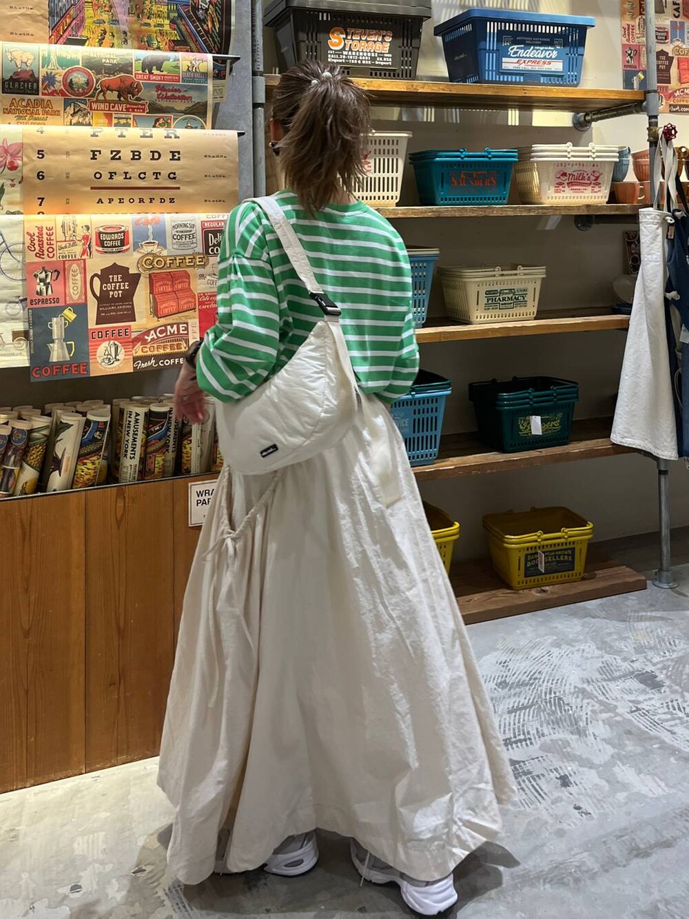 ベージュ系のスカート、ホワイト系のショルダーバッグ、グリーン系のTシャツ/カットソーを着用したレディースの春コーディネートの3枚目の写真