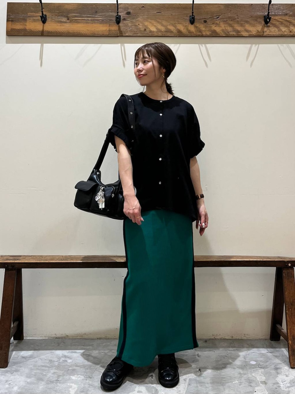 グリーン系のスカート、ブラック系のショルダーバッグ、ブラック系のバレエシューズを着用したレディースの春コーディネートの6枚目の写真