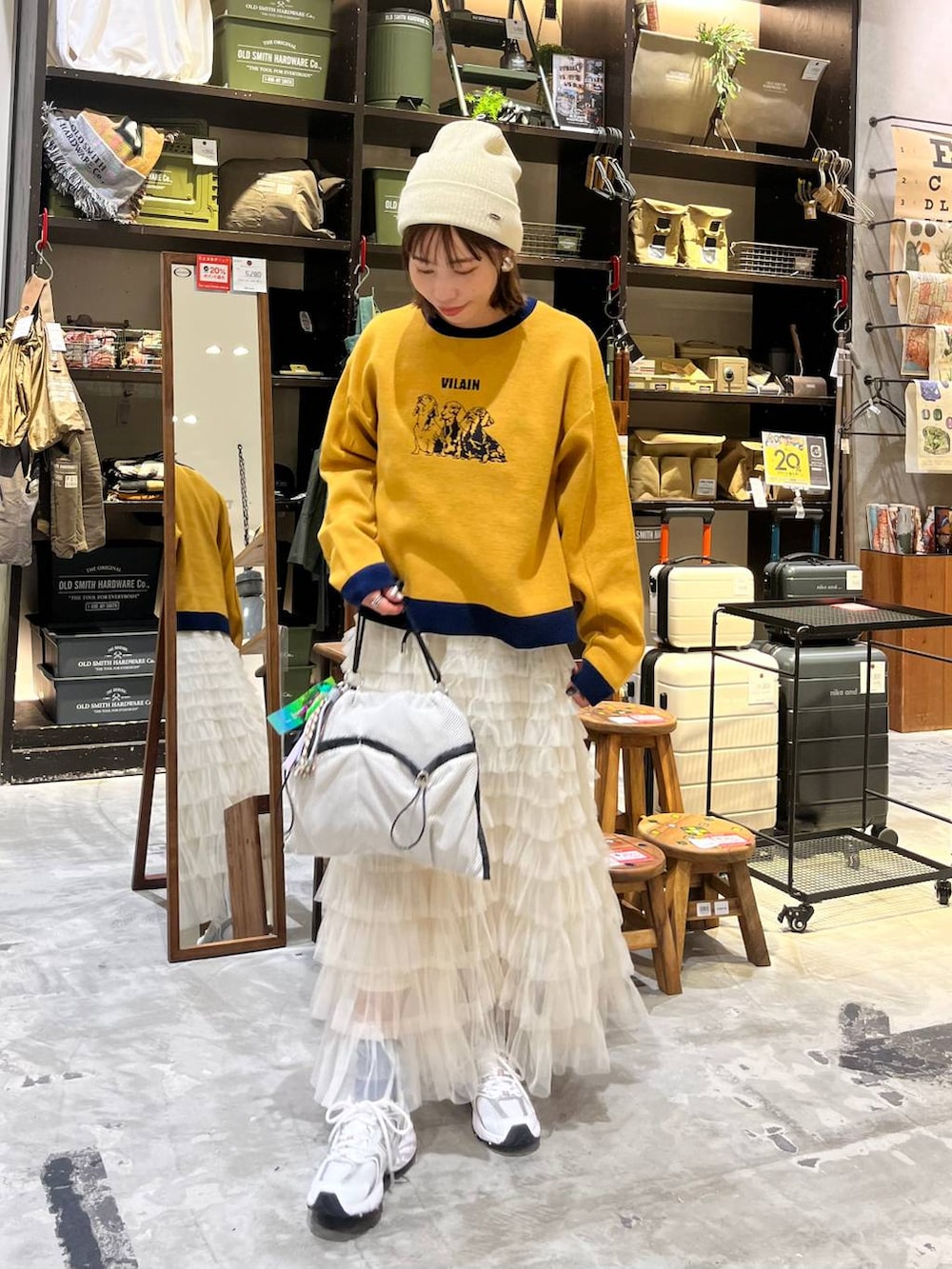 ホワイト系のスニーカー、グレー系のショルダーバッグ、ホワイト系のスカートを着用したレディースの秋コーディネートの5枚目の写真