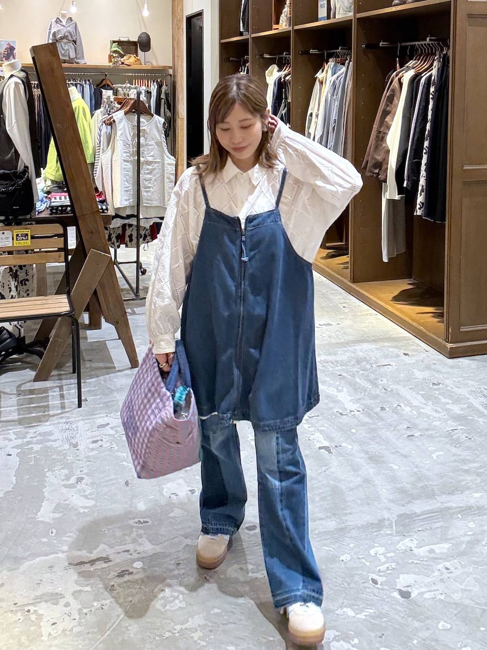 ベージュ系のスニーカー、ブルー系のデニムパンツ、ブルー系のキャミソールを着用したレディースの春コーディネートの4枚目の写真