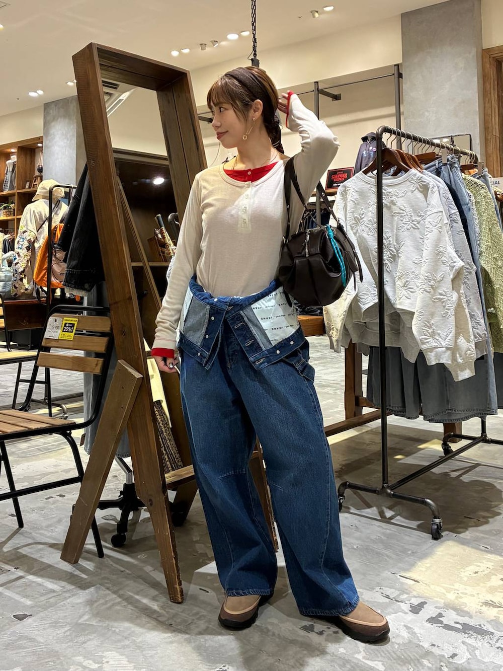 ブラウン系のボストンバッグ、ベージュ系のTシャツ/カットソー、ブルー系のサロペット/オーバーオールを着用したレディースの冬コーディネートの8枚目の写真