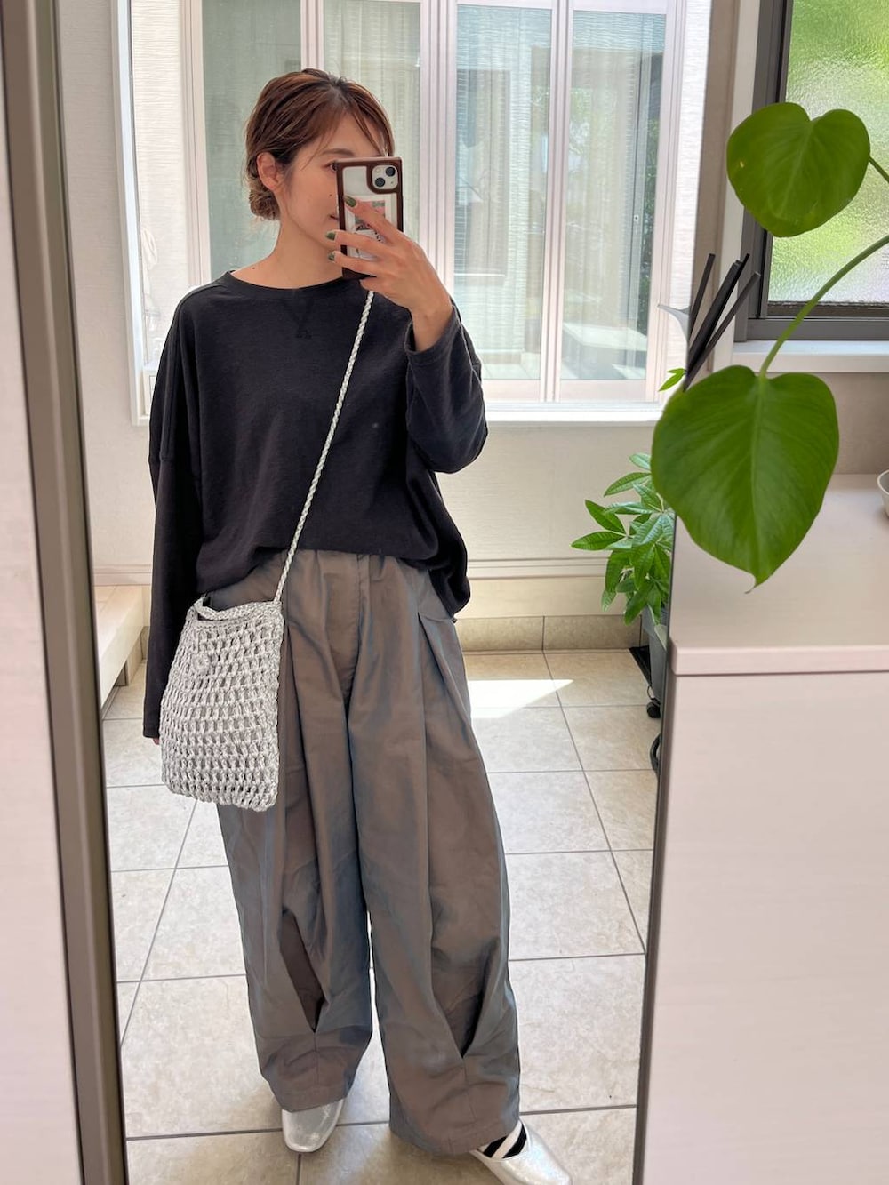 グレー系のショルダーバッグ、シルバー系のパンプス、グリーン系のチノパンツを着用したレディースの夏コーディネートの4枚目の写真