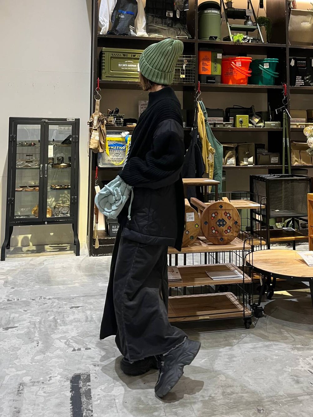 グレー系のスカート、グレー系のTシャツ/カットソー、ブラック系のブルゾンを着用したレディースの冬コーディネートの4枚目の写真