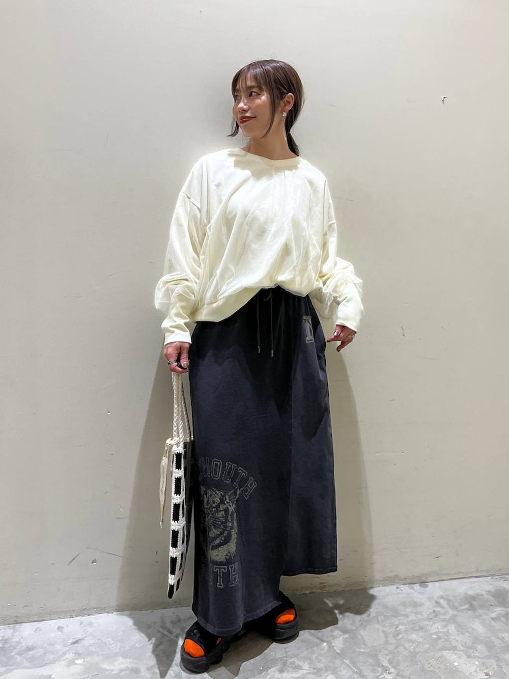 ホワイト系のスウェット、ブラック系のトートバッグ、その他のスカートを着用したレディースの春コーディネートの2枚目の写真