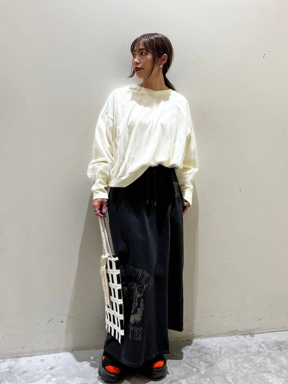 ホワイト系のスウェット、ブラック系のトートバッグ、その他のスカートを着用したレディースの春コーディネートの6枚目の写真