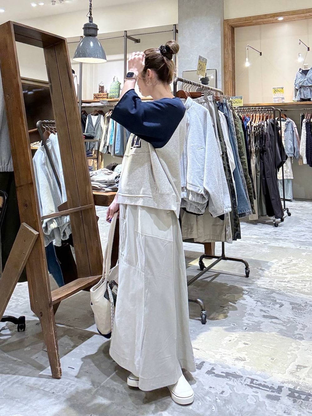 ベージュ系のトートバッグ、ベージュ系のTシャツ/カットソー、ベージュ系のスカートを着用したレディースの春コーディネートの6枚目の写真