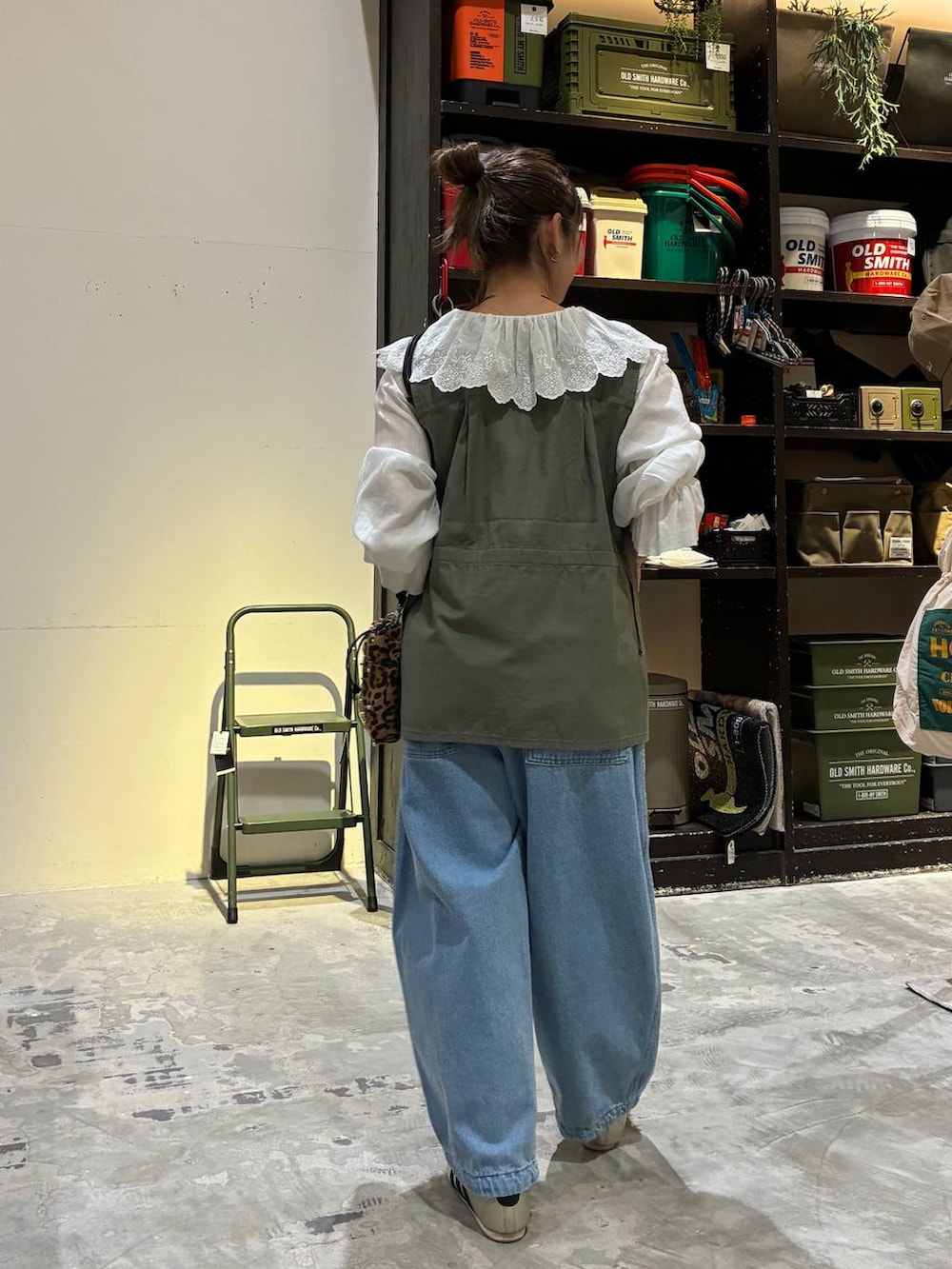 その他のショルダーバッグ、ゴールド系のスニーカー、グリーン系のベストを着用したレディースの冬コーディネートの6枚目の写真