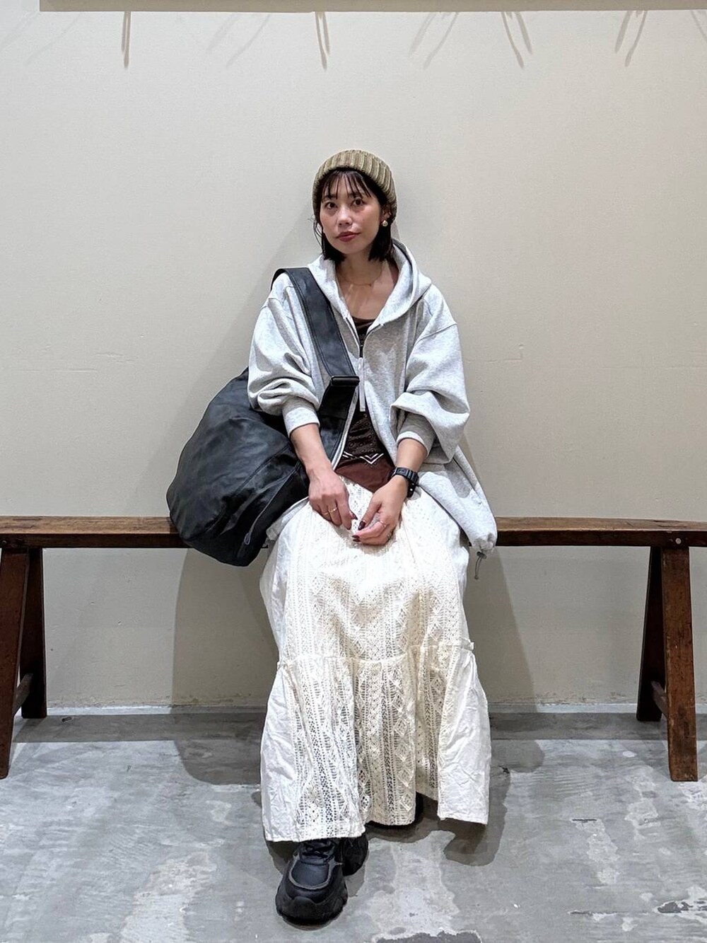 ベージュ系のスカート、ブラック系のショルダーバッグ、グレー系のパーカーを着用したレディースの秋コーディネートの3枚目の写真