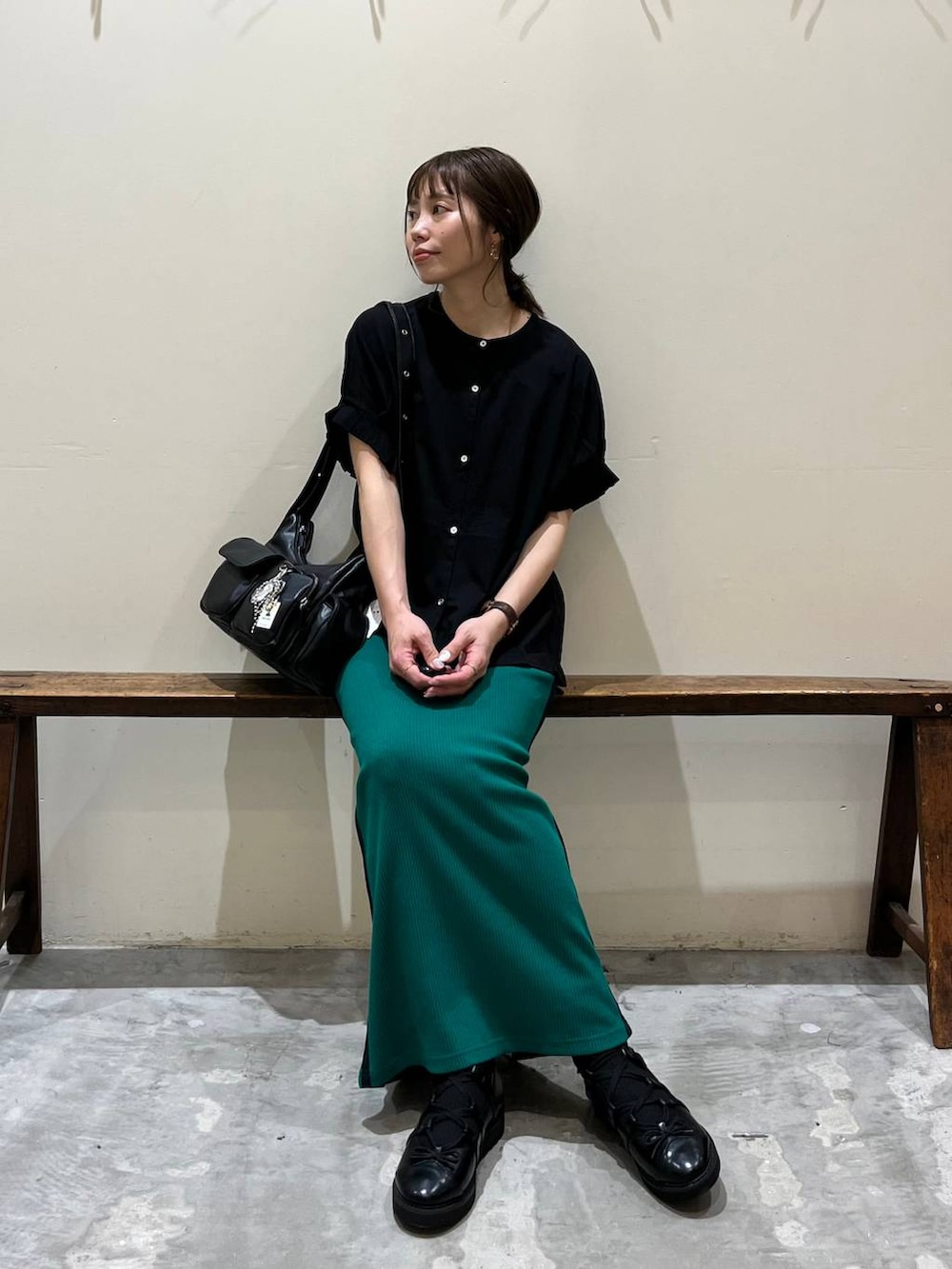 グリーン系のスカート、ブラック系のショルダーバッグ、ブラック系のバレエシューズを着用したレディースの春コーディネートの4枚目の写真