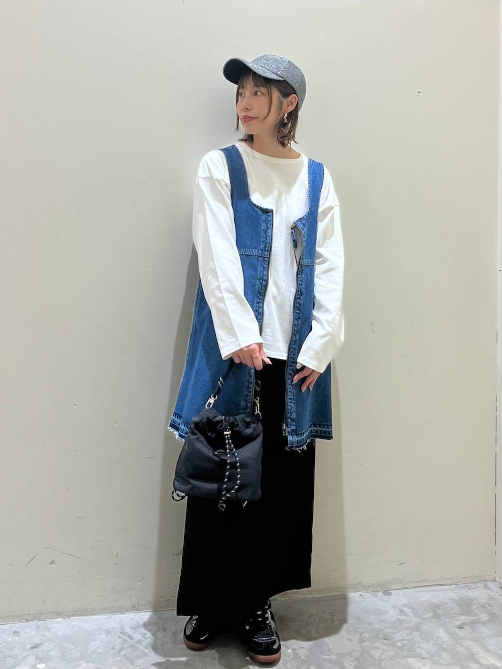 ブラック系のスカート、ブルー系のドレス、シルバー系のスニーカーを着用したレディースの冬コーディネートの6枚目の写真