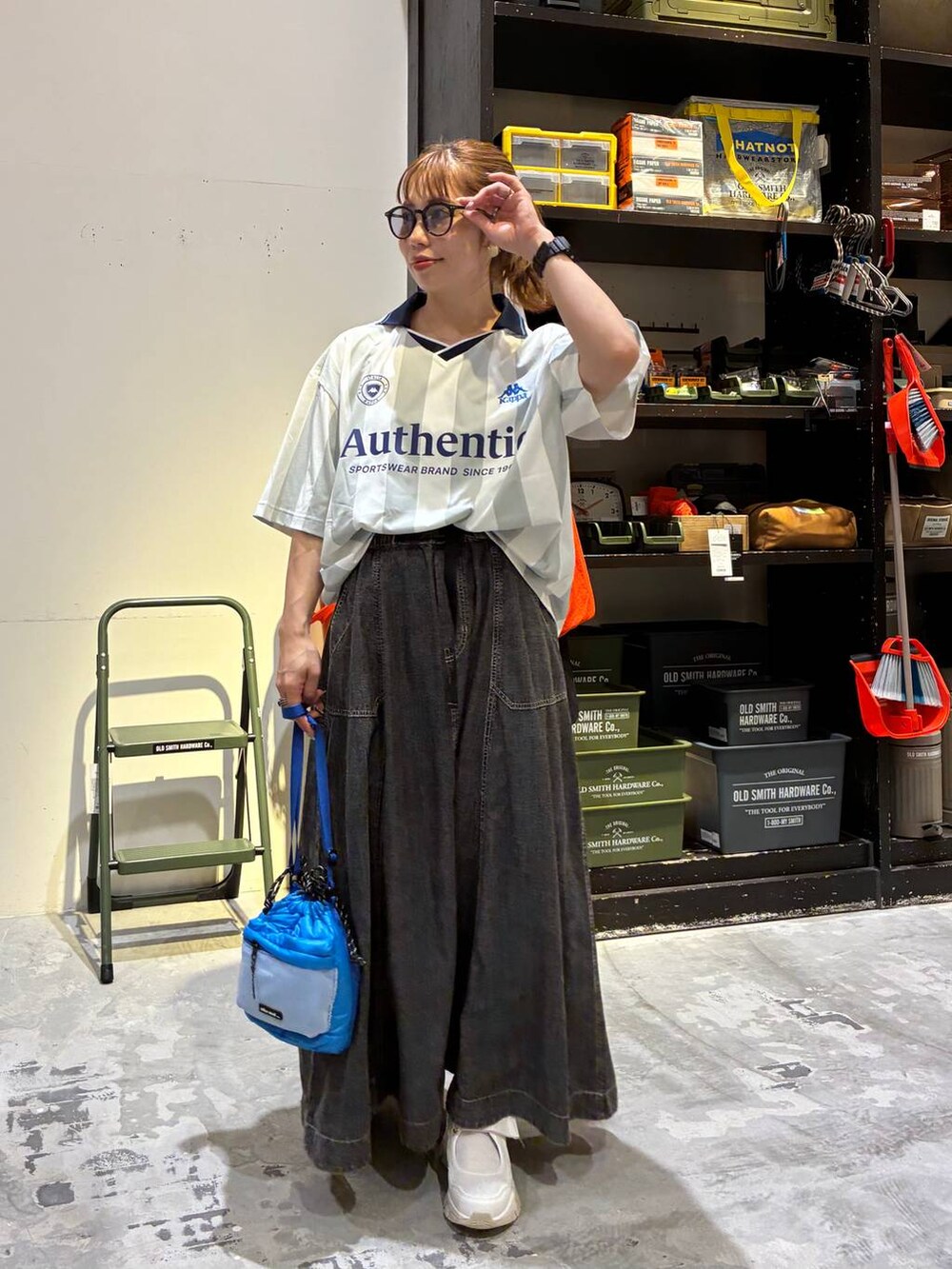 グレー系のスカート、ホワイト系のシャツ/ブラウス、ブルー系のショルダーバッグを着用したレディースの夏コーディネートの2枚目の写真