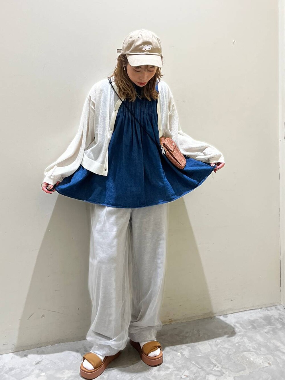 イエロー系のサンダル、ブルー系のベスト、オレンジ系のショルダーバッグを着用したレディースの春コーディネートの5枚目の写真