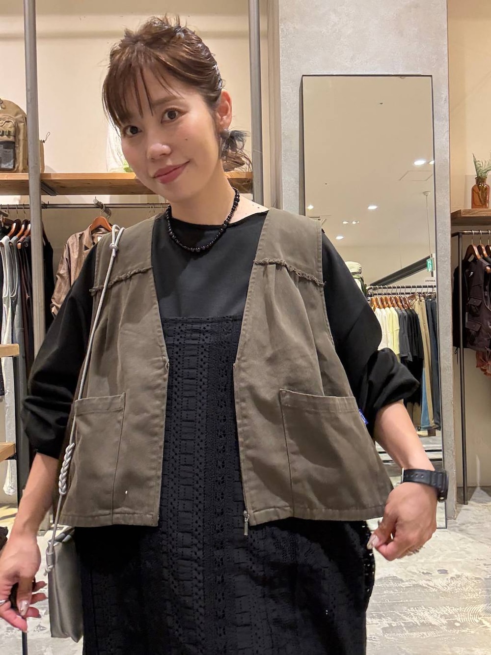 ブラック系のワンピース、ブラック系のスニーカー、シルバー系のショルダーバッグを着用したレディースの秋コーディネートの5枚目の写真