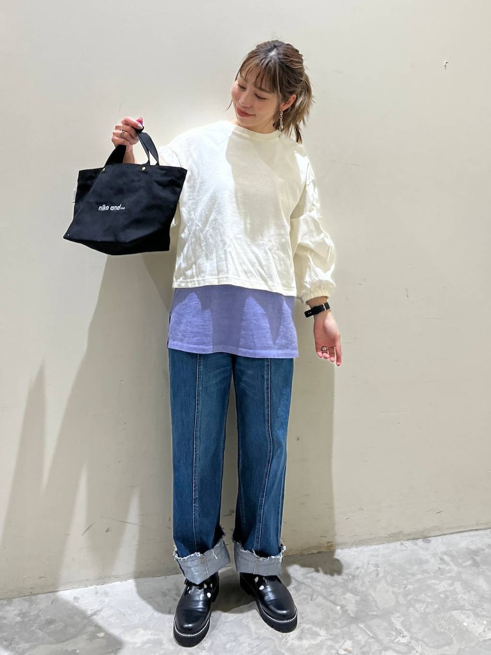 パープル系のTシャツ/カットソー、ホワイト系のTシャツ/カットソー、ブラック系のトートバッグを着用したレディースの冬コーディネートの3枚目の写真