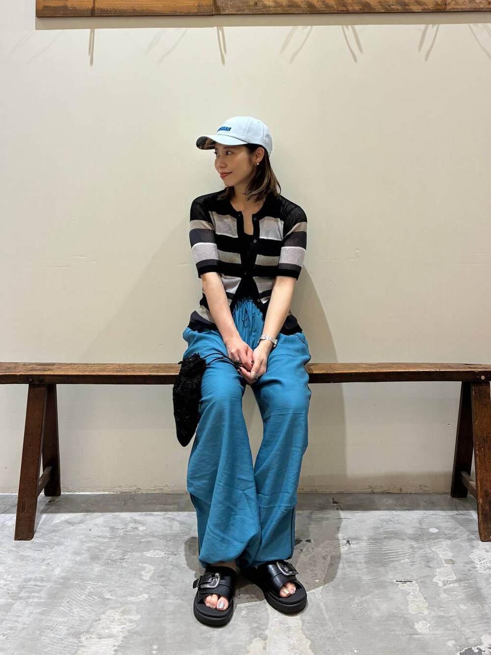 ブルー系のその他パンツ、ブラック系のショルダーバッグ、ブラック系のサンダルを着用したレディースの春コーディネートの2枚目の写真