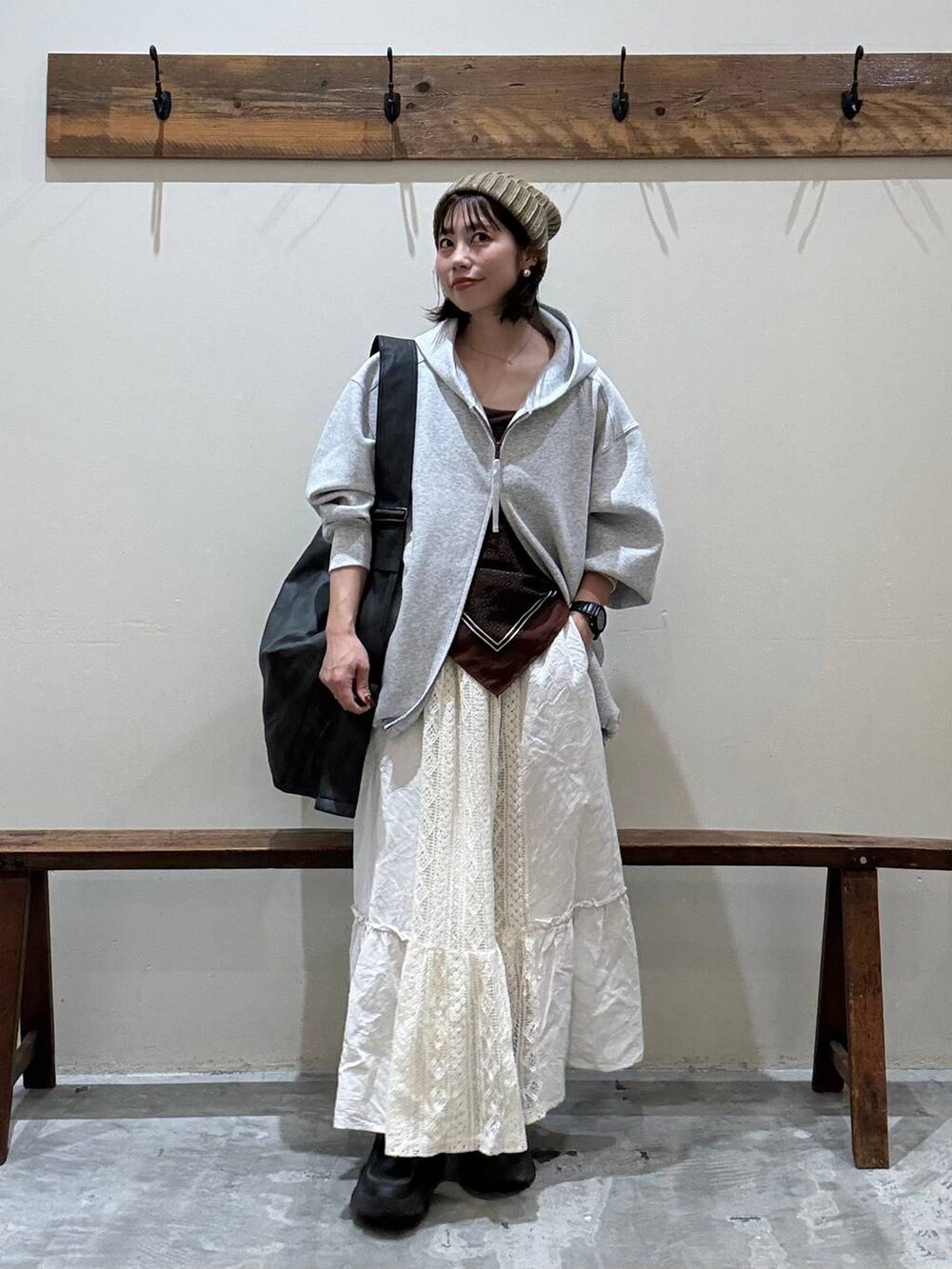 ベージュ系のスカート、ブラック系のショルダーバッグ、グレー系のパーカーを着用したレディースの秋コーディネートの8枚目の写真