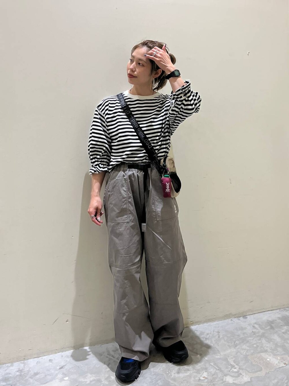 グレー系のその他パンツ、ブラック系のスニーカー、ホワイト系のTシャツ/カットソーを着用したレディースの春コーディネートの4枚目の写真